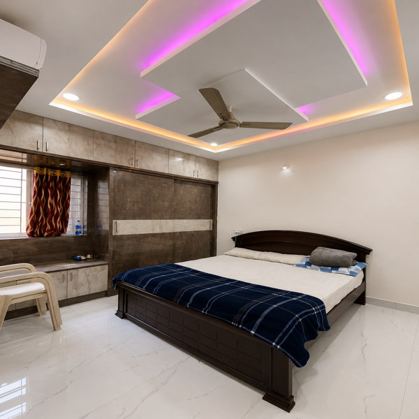Modern bedroom, luxury bedroom, elegant interior, contemporary bedroom, master bedroom, king size bed, wooden bed, dark wood furniture, blue bedspread, striped blanket, white bedsheets, pillows, ceiling fan, false ceiling, LED lighting, pink lighting, warm lighting, recessed lights, marble flooring, glossy floor, built-in wardrobe, wooden wardrobe, wall cabinets, window, curtains, patterned curtains, air conditioner, bedside area, spacious room, residential interior, home decor, interior design, modern home, stylish bedroom, cozy bedroom, sophisticated decor, premium interiors, clean room, bright room, ceiling design, architectural lighting, ambient lighting, bedroom furniture, storage cabinets, marble tiles, contemporary decor, luxury home, peaceful bedroom, Indian home interior, real estate interior, home photography.